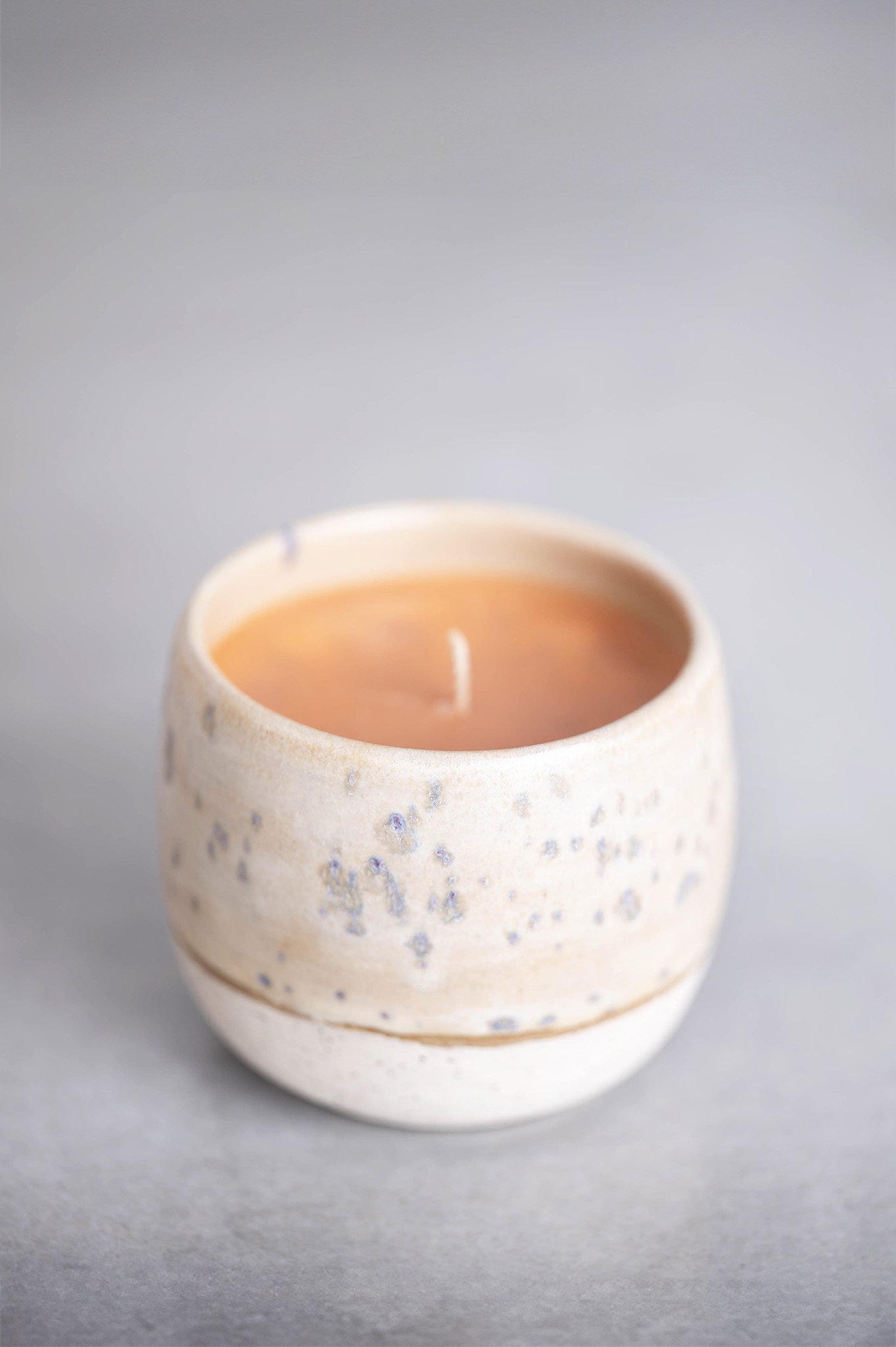 świeca w prostym beżowym pojemniku ceramiczntm